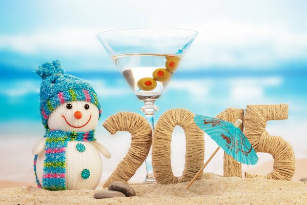 Chiffres 2015 sur la plage entourée d un bonhomme de neige et un verre à Martini avec un parapluie