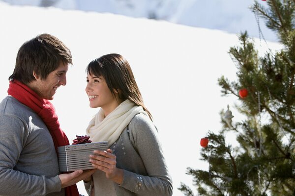Heureux gars et fille se donnent des cadeaux