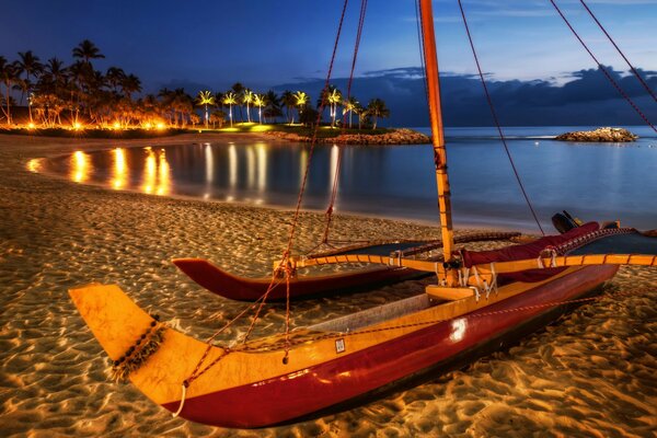 Bateau sur le sable au milieu des lumières de la nuit